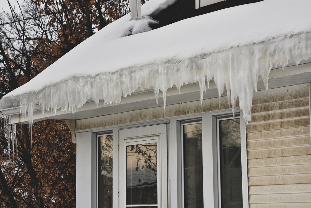 Ice Dams. Melting Snow On Roof Creating Ice Dam In Gutter.