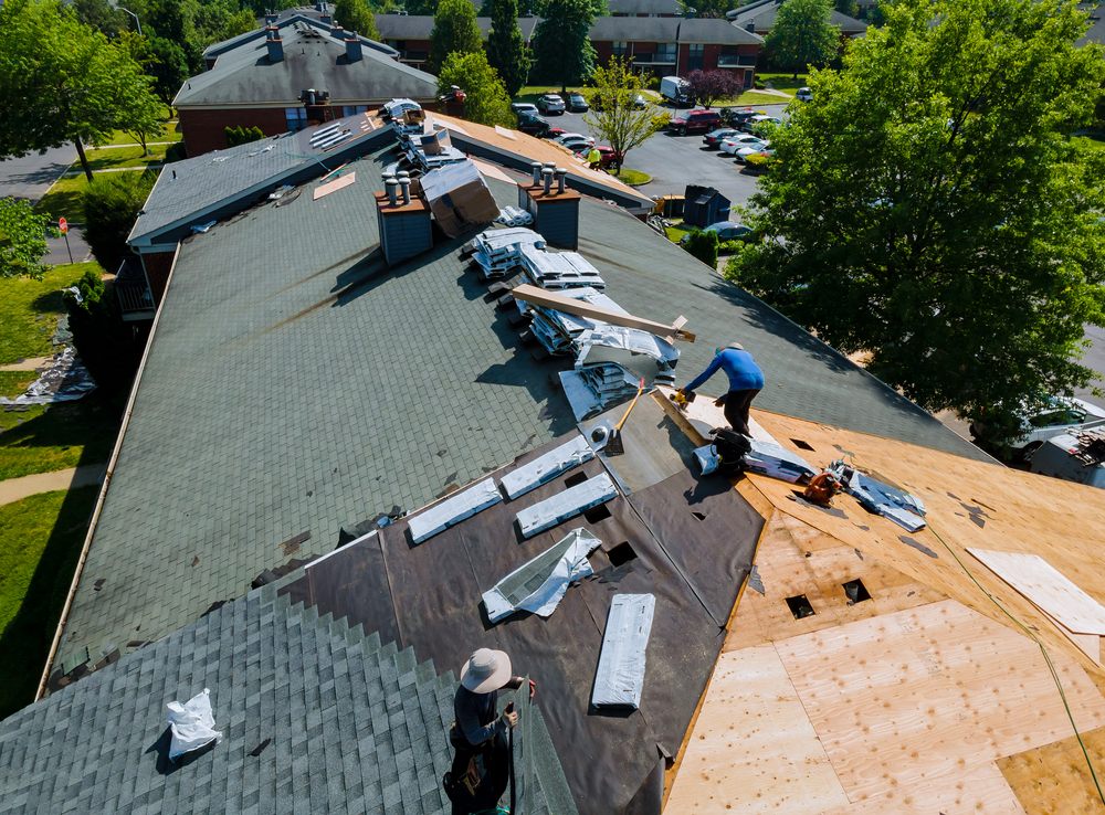 Roof Repair. Construction worker on a roof the house performing roof repairs.
