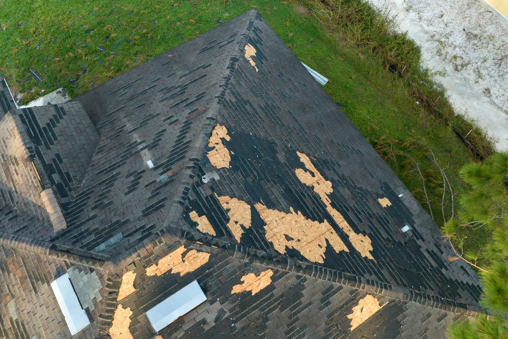 Roof Repair. Damaged house roof with missing shingles Consequences of natural disaster.