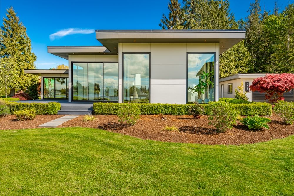 Flat Roofing Services In Ottawa. Contemporary home exterior on lakeshore with flat roof and large feature windows.