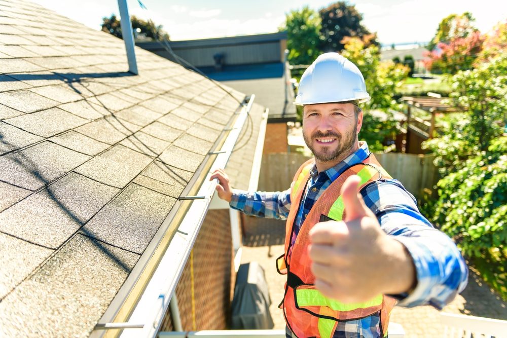 A,Man,With,Hard,Hat,Standing,On,Steps,Inspecting,House Roofing Inspections in Ottawa. A man with a hard hat is standing on the ladder, inspecting the house roof.