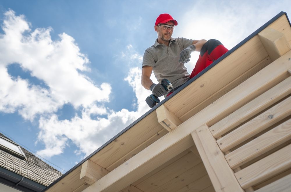 The Financial Benefits of Regular Roof Maintenance for Ottawa Residents. Professional Construction Worker on the roof performing roof maintenance.