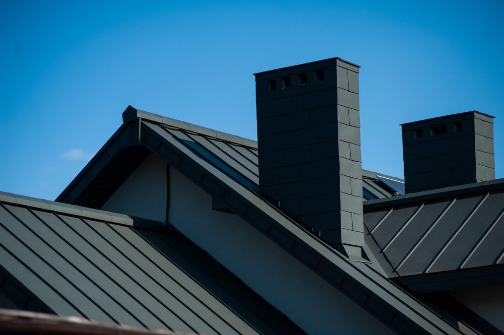 Why Metal Roof Repair is a Smart Investment for Ottawa Homeowners. roof with black tile. modern roof tiles of metal. modern building in the city.